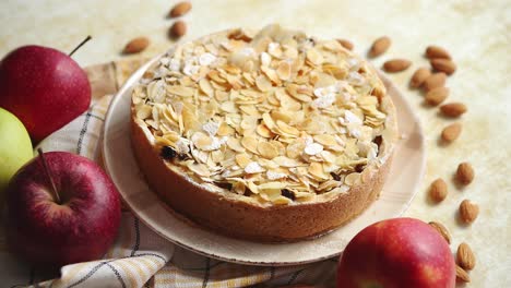freshly baked homemade apple pie with almond flakes cake on yellow