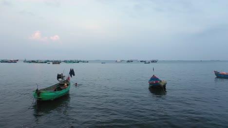 aerial tracking shot of a small group of vietnamese fishing boats early in the morning in vung tau