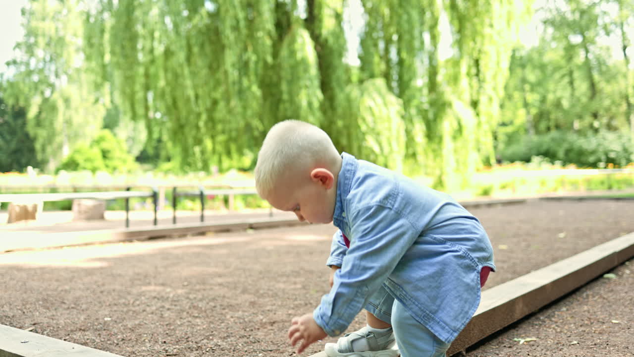 Un bambino di 2 anni in maglietta e pantaloncini a passeggio d'estate in un parco cittadino. Il bambino corre e gioca all'aperto. Uno stile di vita sano per un bambino. Un bambino piccolo che cammina per strada