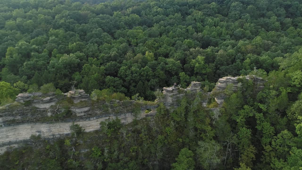 Aerial shot along rocky ridge in green Tennessee hills.
