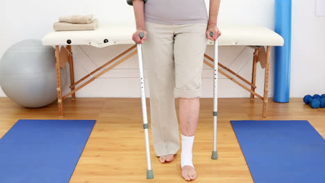 injured patient in crutches walking towards camera