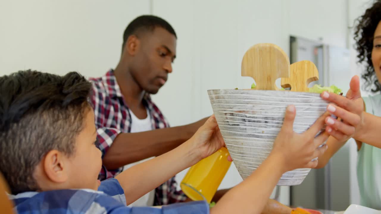 Black family having food on dining table at home 4k