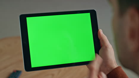 man hand touching green tablet screen closeup. manager holding mockup device