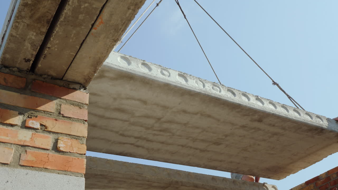 una grúa instala un panel de piso en un edificio de varios pisos una vista inferior