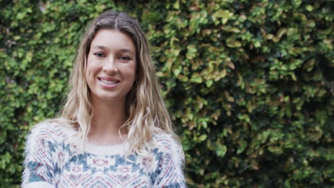 portrait of happy biracial woman with blonde hair in garden, slow motion, copy space