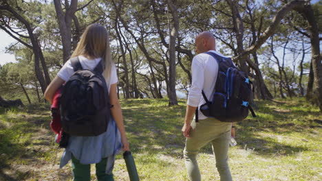 pareja de mochileros caminando juntos en el bosque