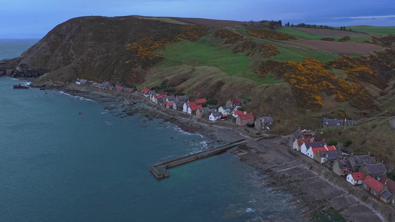 Wunderschöne Luftaufnahmen, die das historische Fischerdorf Crovie zeigen, eingebettet zwischen den Klippen und der Nordsee in Aberdeenshire, Schottland.