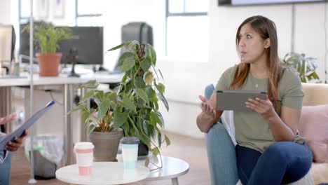 diversas compañeras de negocios en discusión usando tableta en una reunión casual en la oficina, cámara lenta