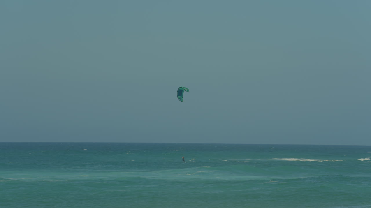 hombre kitesurf en el océano, deporte extremo de verano a cámara lenta en portugal