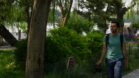 european tourist man walks with a camera visiting beihai park, china