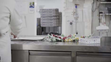 slow motion handheld panning shot of an employee in a candy factory in medina sidonia putting packaged candy aside