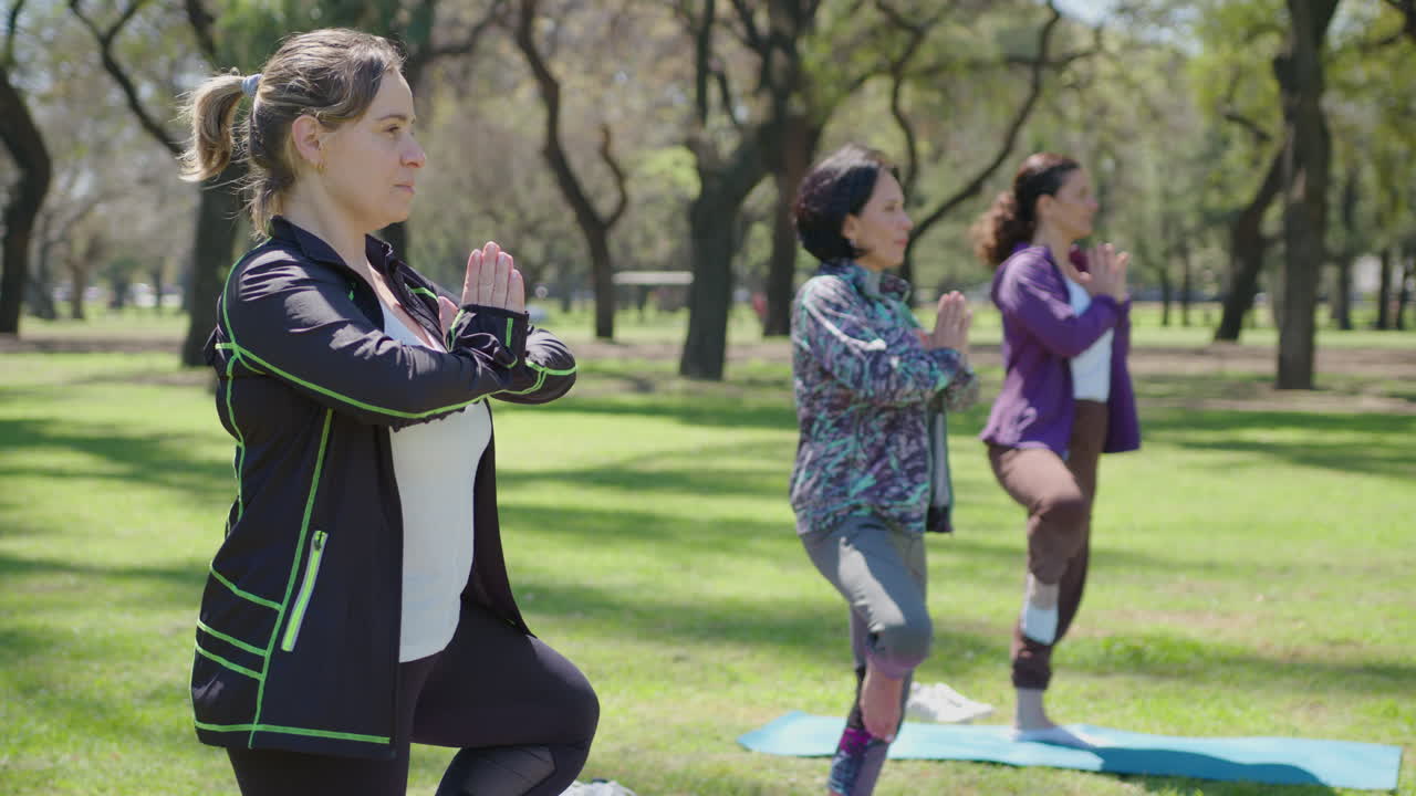 mujeres practicando yoga en un parque