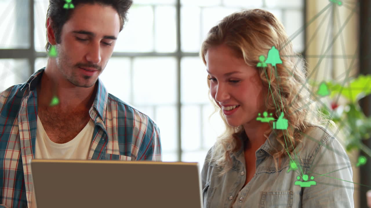 анимация двух глобусов цифровых икон против белого мужчины и женщины на ноутбуке в офисе