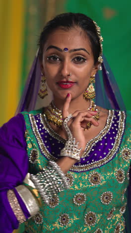 vertical video waist up studio shot of female kathak dancer performing dance wearing traditional indian dress