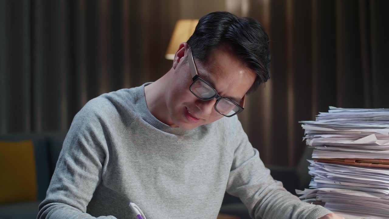 집 에서 문서 를 작업 하는 동안 카메라 에 미소 짓는 아시아인 의 근접 사진