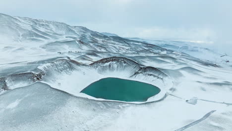 krafla volcanic caldera blue lake in iceland during winter - aerial shot