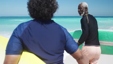 pareja de ancianos corriendo con tablas de surf