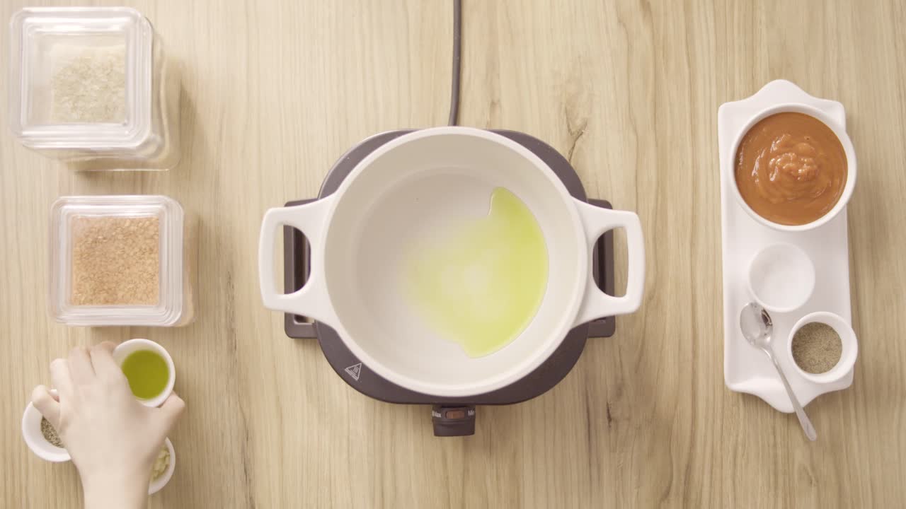 verter aceite en una olla, mezclarlo con ajo y revolver, vista superior estática