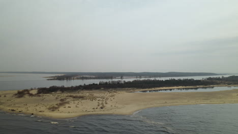 Aerial-shot-showing-River-Mouth-of-Vistula-flowing-into-Baltic-Sea-during-cloudy-and-sunny-day-in-Poland