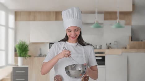 feliz india mujer chef profesional haciendo comida mientras explica