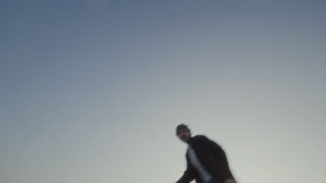 romantic couple spinning and running excitedly in field at golden sunset