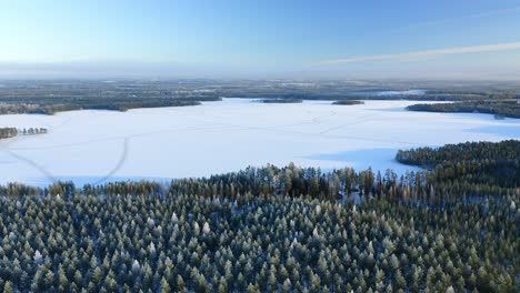 Sich-Vorwärts-Bewegende-Antenne-über-Einem-Zugefrorenen-See-Mit-Waldinseln