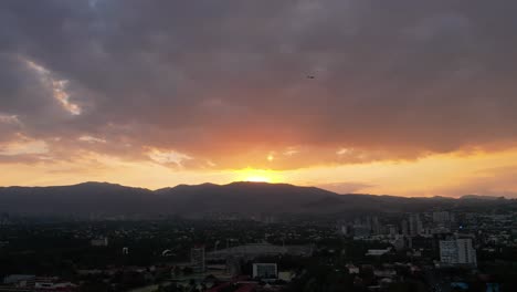 puesta de sol en la ciudad de méxico cerca de la universidad nacional, con un avión cruzando el cielo