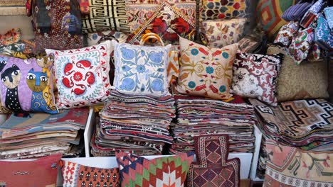 colorful turkish rugs and pillows on display in a market