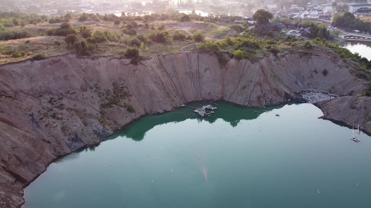 vista aérea de un lago minero en ucrania al amanecer con niebla y casas en el fondo