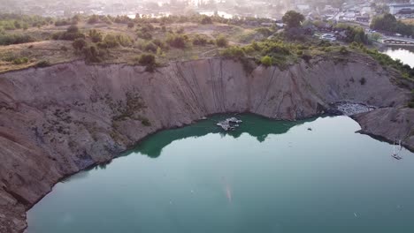 aerial view of a mine lake in ukrain at sunrise with fog and houses in the background