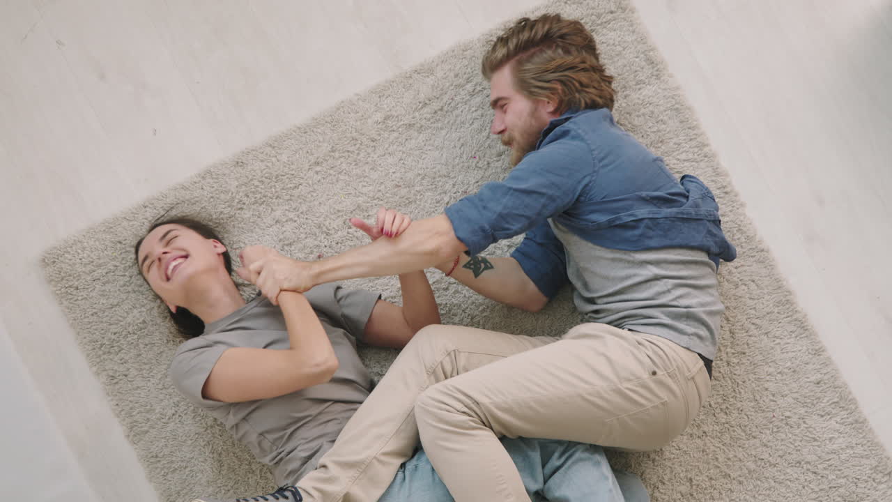 Top View of Couple Play Fighting on Floor