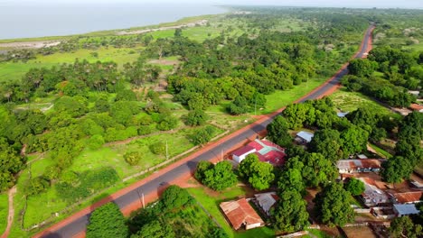 african rural village with natural vegetation, sea coast and modern access road