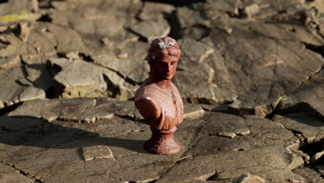 ancient-statue-of-woman-on-rocky-stones