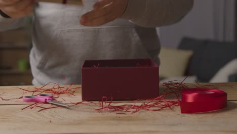 primer plano de hombre en casa regalo envolviendo romántico san valentín presente en caja 2