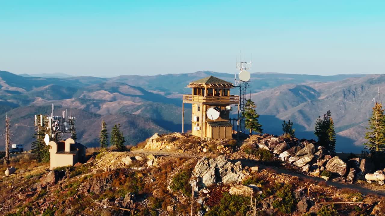 Fire lookout tower on California mountain under clear blue sky