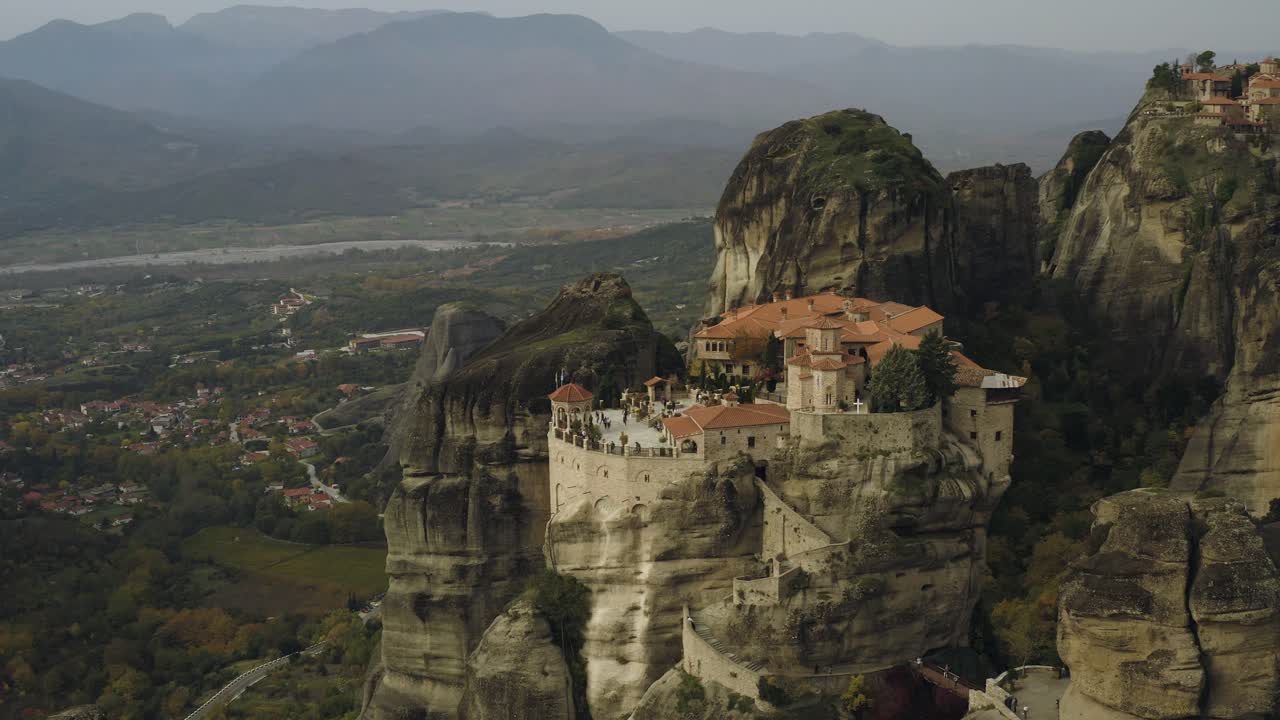 vista aérea alrededor de un gran monasterio en la cima de una montaña empinada, en meteora, grecia - dando vueltas, tiro de drones