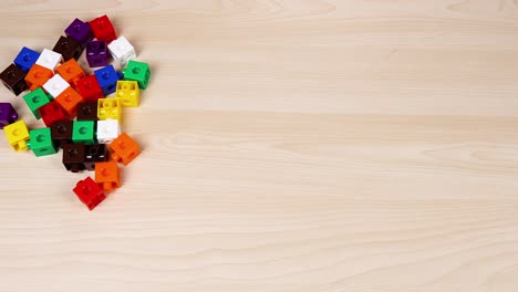 hands arranging colorful cubes on a table