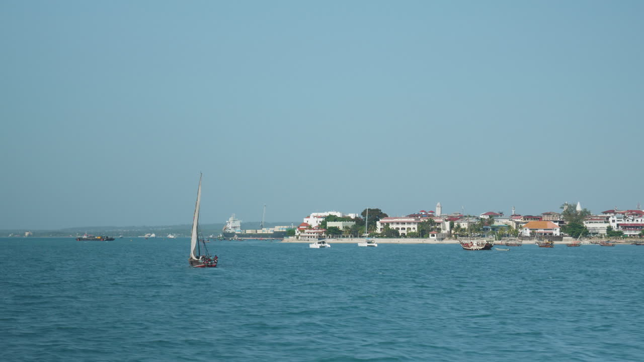 barco de vela en marcha cerca de la costa de la ciudad de piedra de zanzíbar en un día claro y soleado