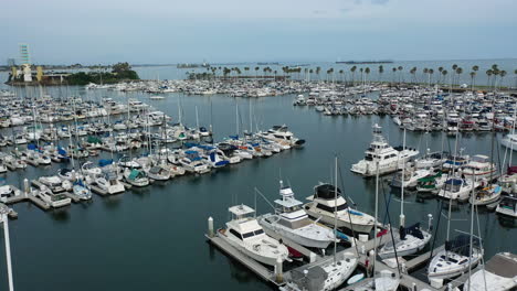 Aerial-view-low-over-boats-at-the-Long-Beach-Shoreline-Marina,-in-cloudy-Los-Angeles,-USA