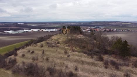 sobrevuelo de una colina con ruinas antiguas que revelan un pueblo y un polígono industrial