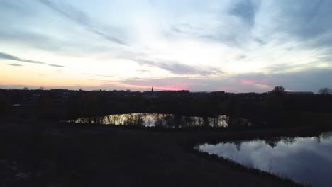 Aufsteigende-Luftaufnahme,-Die-Die-Stadt-Bei-Sonnenuntergang-In-Belgien-Zeigt