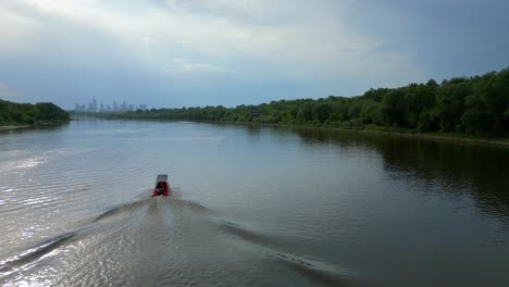 Toma-Aérea-De-Seguimiento-De-Una-Lancha-Motora-De-Rescate-Roja-En-El-Río-Vístula.