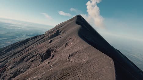 fuego volcano peak and mountain ridges in guatemala, aerial fpv view