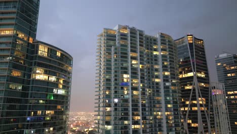 aerial tilt down of skyscraper buildings illuminated at night in miami downtown
