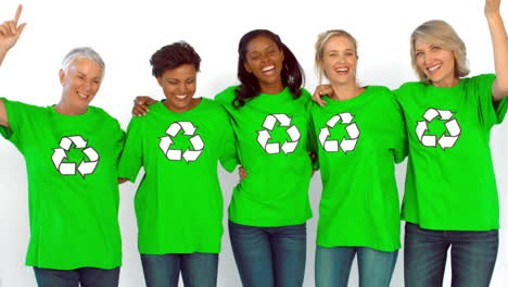 mujeres bailando y usando camisa verde con símbolo reciclable