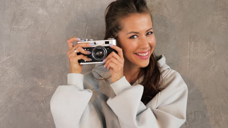 mujer tomando una foto con una cámara retro