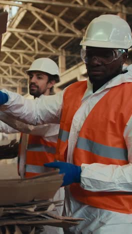 recycling plant workers sorting cardboard