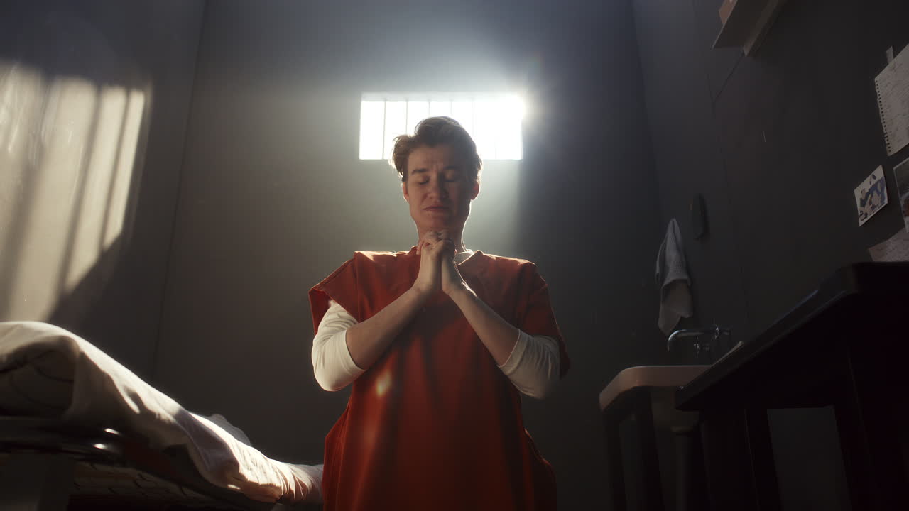 Hopeful Female Inmate Praying to God in Prison Cell
