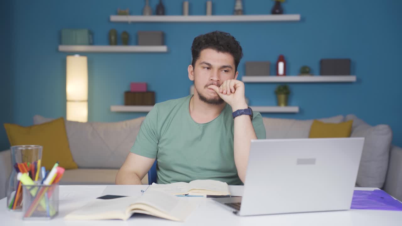 estudiante masculino estresado y mordiéndose las uñas.