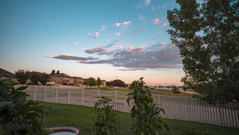 backyard garden at sunset, tilt up panoramic movement to reveal the sky and neighborhood - motion time lapse